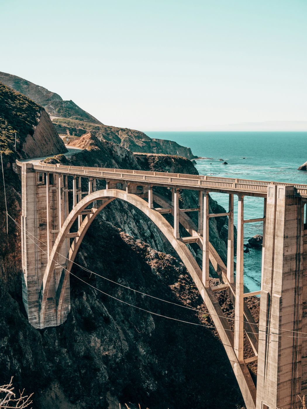 A concrete arch bridge crossing a coastal canyon